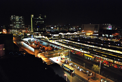 804790 Overzicht van het Stationsplein met het Stationsplateau en het Centraal Station te Utrecht, bij avond.